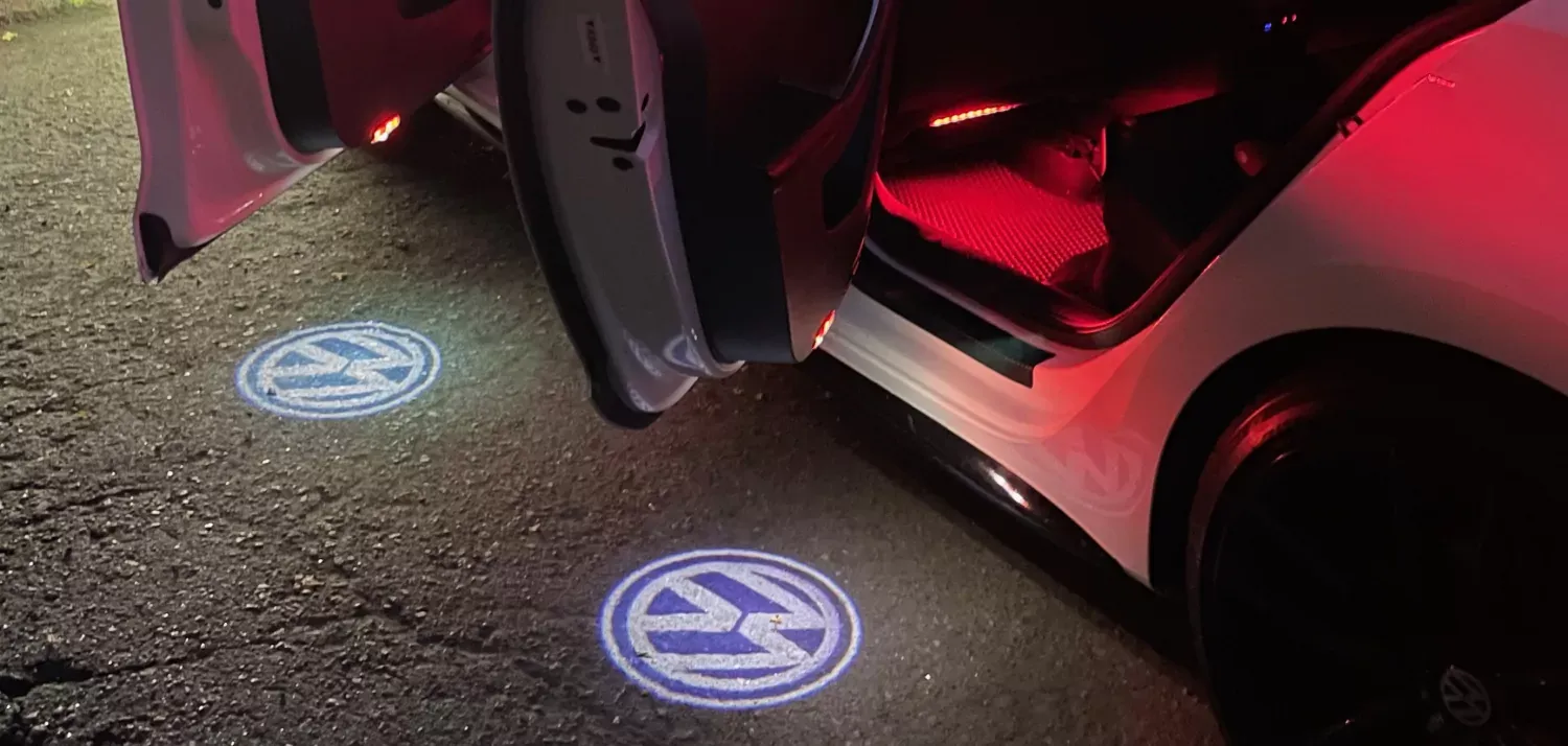 Червона підсвітка ніг та дверей зі значками VW